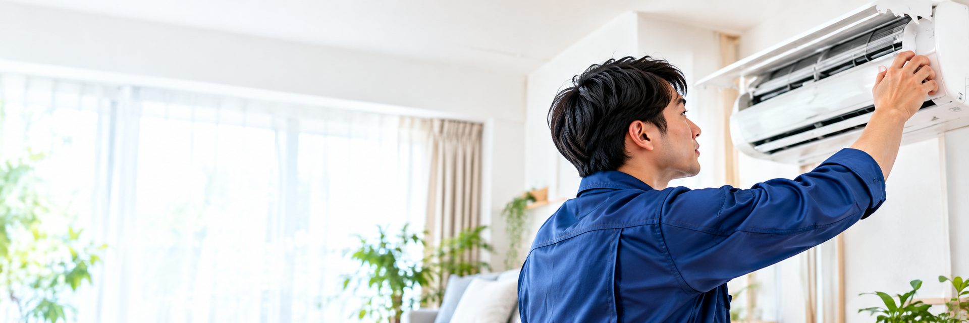飯塚のエアコンクリーニング前に本体を確認するスタッフ